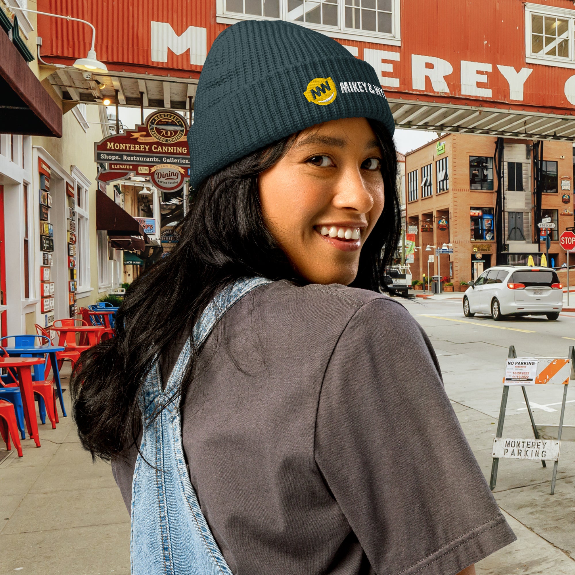 Person wearing a beanie with a logo in an urban setting